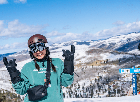 woman at top of Pajarito mountain snowboarding